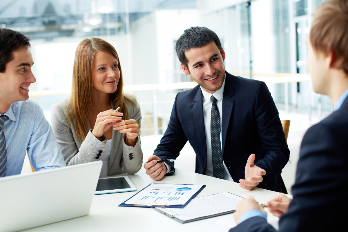 Groupe d'employés souriants échangeant avec leur manager