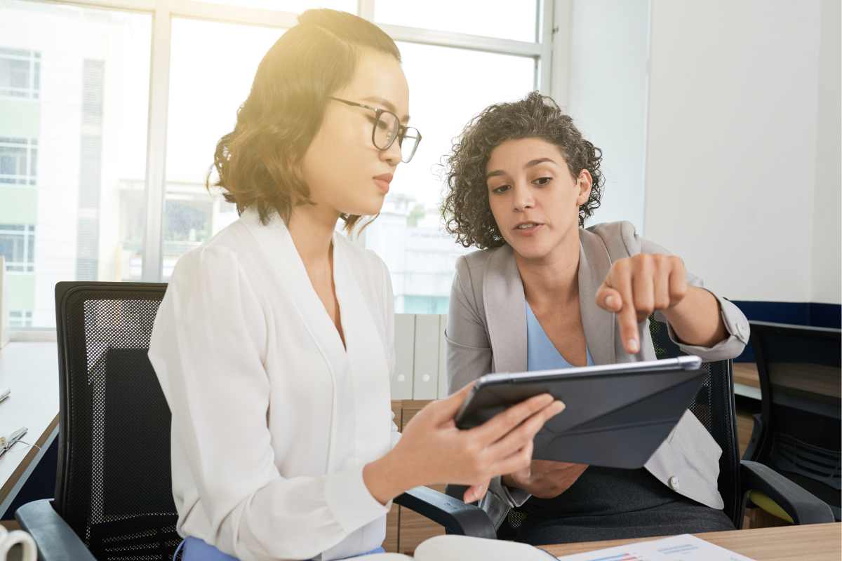 Deux collaboratrices consultant une tablette dans un bureau