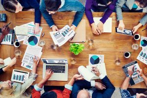 Vue de dessus d'une grande table de travail couverte de documents chiffrés
