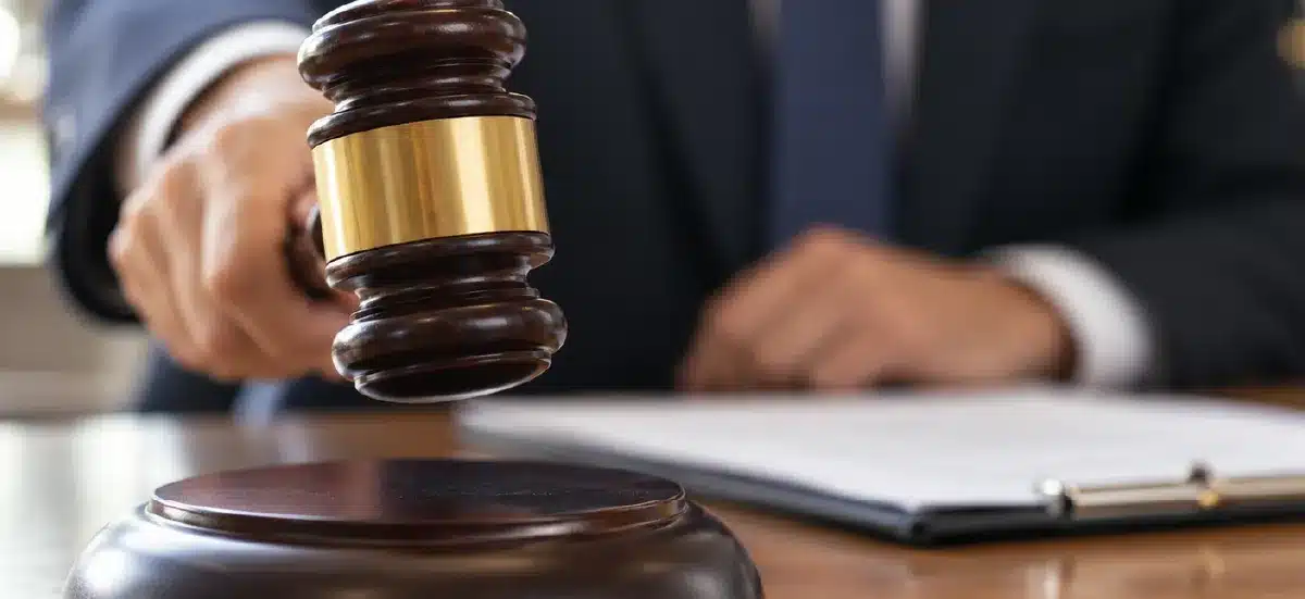 Juge abattant son marteau sur le bureau, document posé à côté