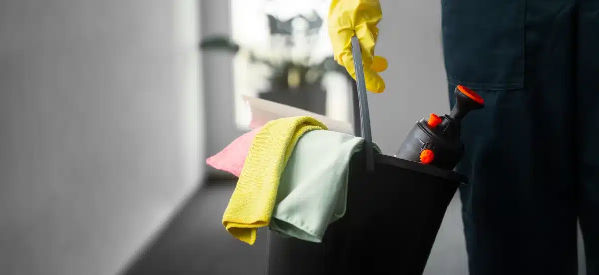 Seau de nettoyage avec chiffons et produits, agent d'entretien en arrière-plan