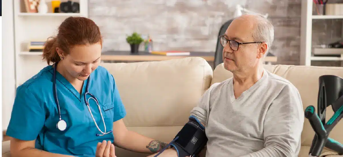 Infirmière prenant la tension artérielle d'un patient âgé à domicile