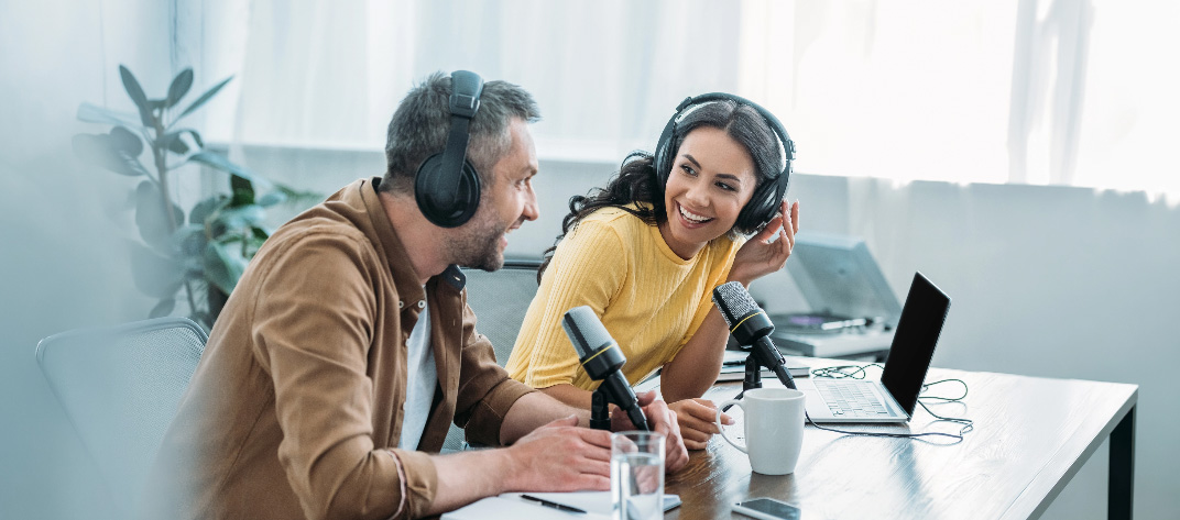 Deux personnes avec casques et micros lors de l'enregistrement d'un podcast