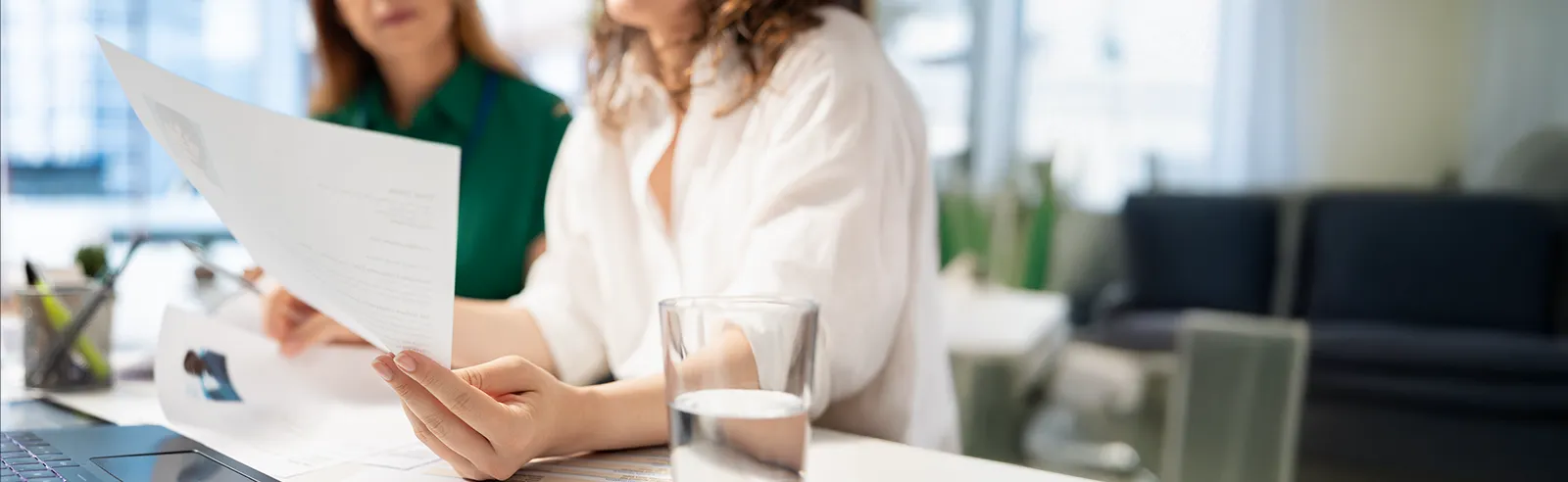 Gros plan sur des mains tenant des CV lors d'un entretien