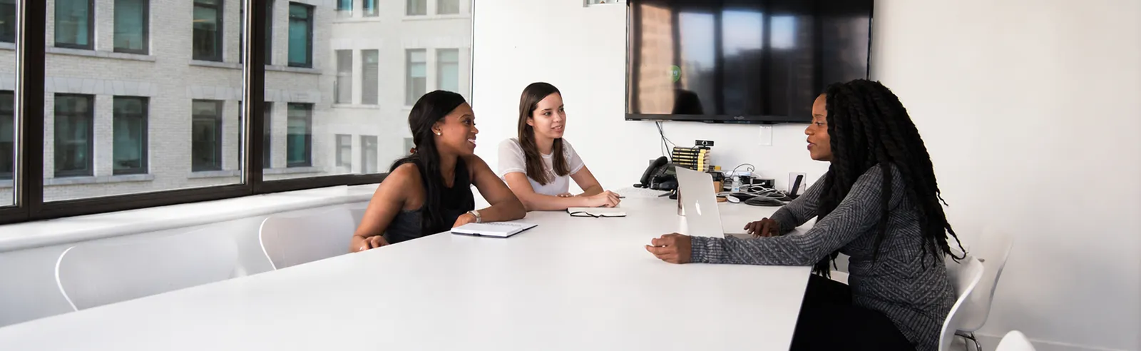 Trois femmes en entretien autour d'une table de réunion