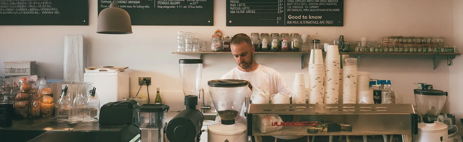 Barista préparant une commande derrière le comptoir d'un café