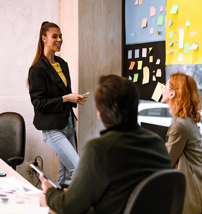 Intervenante animant un atelier devant un mur de post-it