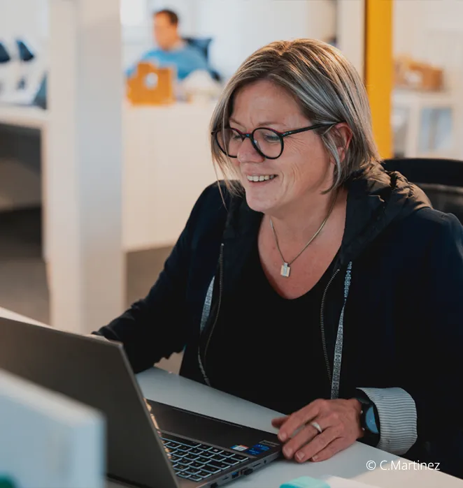 Consultante One RH souriante devant son ordinateur portable