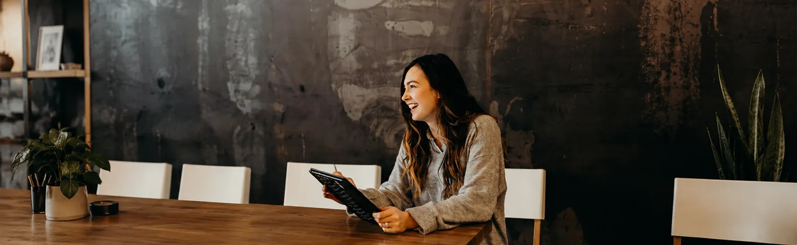 Femme souriante avec une tablette à une table de réunion