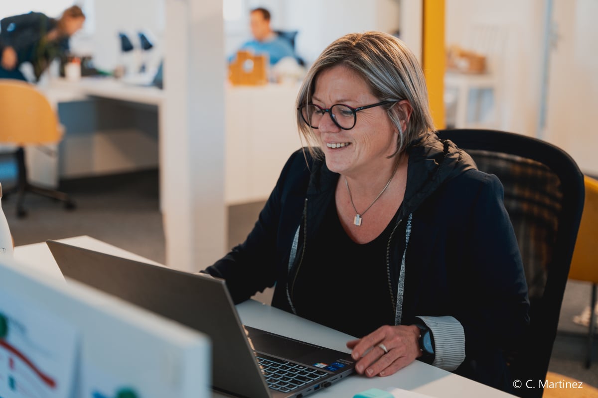 Consultante One RH souriante devant son ordinateur portable