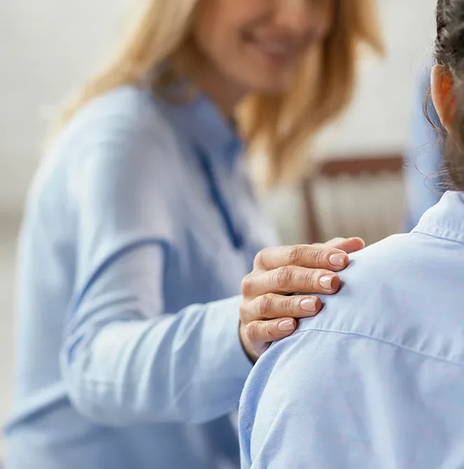 Main posée sur l'épaule d'une personne en signe de soutien